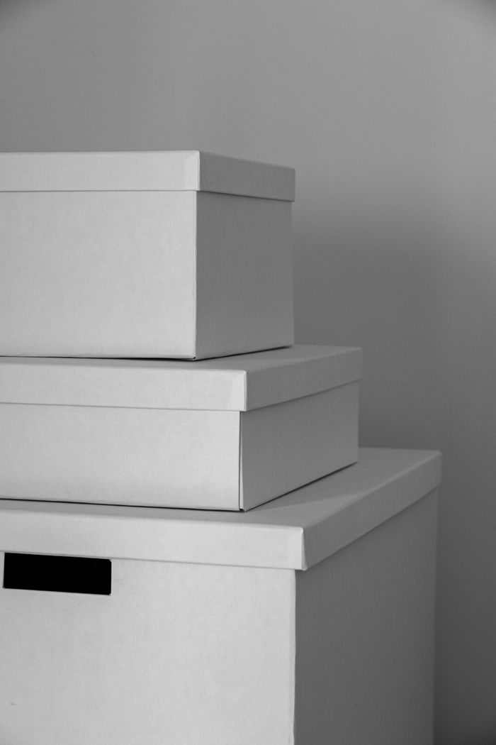 Aesthetic composition of three stacked white storage boxes in a minimalist indoor setting.